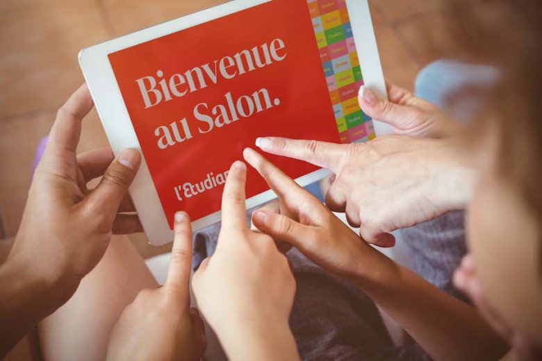 photo de mains qui pointent vers l'affiche du salon de l'étudiant